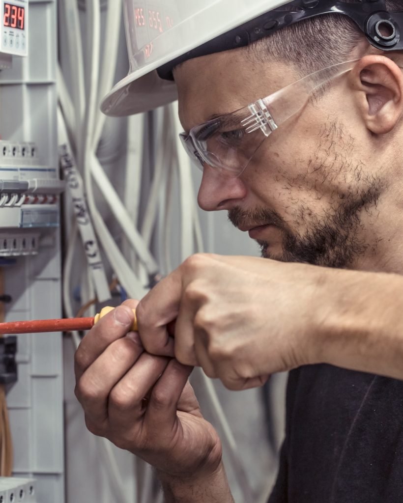 a-male-electrician-works-in-a-switchboard-with-an-electrical-connecting-cable.jpg a-male-electrician-works-in-a-switchboard-with-an-electrical-connecting-cable.jpg